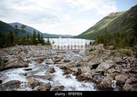 Montagne sauvage qui traverse la forêt de sapins. river se jette dans le lac. Banque D'Images