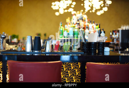 Comptoir de bar classique avec des bouteilles à l'arrière-plan flou Banque D'Images