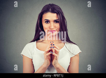 Libre d'une magouille sournoise jeune femme traçant quelque chose d'isolé sur fond gris. Les émotions humaines sentiments négatifs Banque D'Images