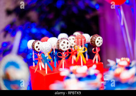 Candy bar sur boy's Birthday party avec beaucoup de différents bonbons, pop-corn, boissons et grand gâteau debout sur un tonneau. Décorées dans des couleurs vives. H Banque D'Images