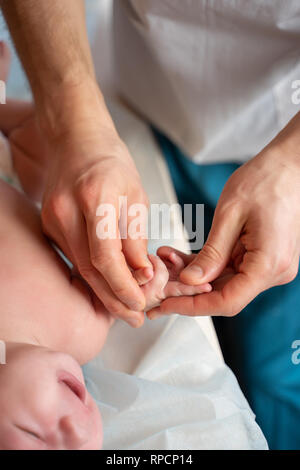 Image de mains de masseur et bébé sur la table de massage. Banque D'Images