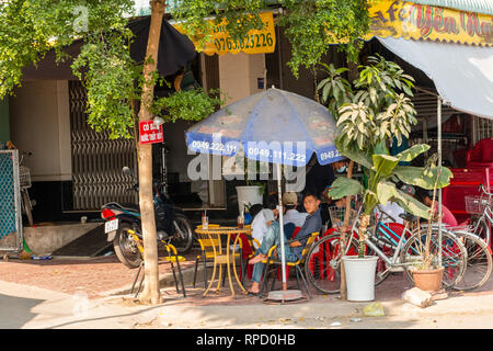 Les hommes vietnamiens locaux se détendent avec une boisson fraîche à l'extérieur du café bar local, Tan Chau, an Giang province, Mekong Delta Vietnam, Asie Banque D'Images