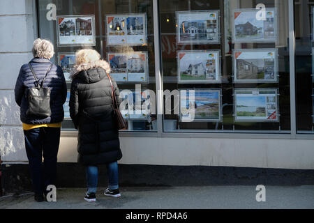 Deux femmes à la fenêtre dans un des agents immobiliers à Falmouth, Cornwall. Banque D'Images