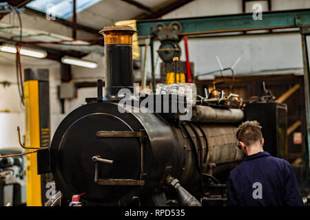 Un ingénieur d'effectuer l'entretien annuel et les réparations sur le petit train à vapeur qui transporte des passagers le long de la bure Valley Railway à Norfolk Banque D'Images