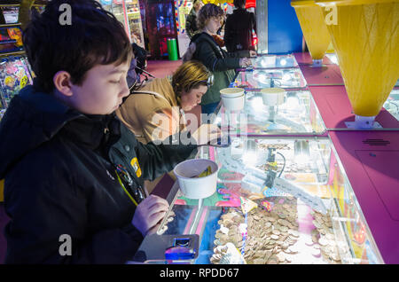 Une mère et son fils jouer deux penny tombe dans une salle de jeux électroniques, à Bournemouth, Dorset, UK Banque D'Images