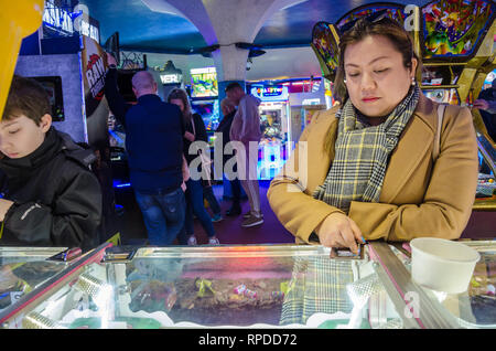 Une mère et son fils jouer deux penny tombe dans une salle de jeux électroniques, à Bournemouth, Dorset, UK Banque D'Images