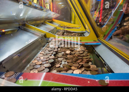 Un jeu de deux chutes penny où deux pence pièce de monnaie équilibre précaire sur le bord d'une tablette inférieure en attente d'être arrachée et a gagné. Banque D'Images
