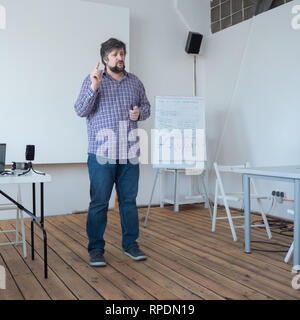 Concept de l'école du cinéma. Le Professeur de cours à l'école avec plancher en bois. Caucasian teacher standing in conférences hall. Partage de l'expérience Banque D'Images