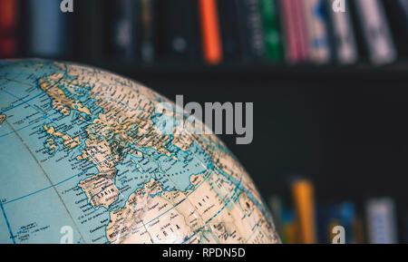 Close up of desktop globe, l'Europe et l'Afrique du Nord. En arrière-plan n'est pas mise au point livres sur des étagères Banque D'Images