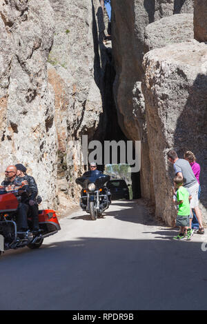 CUSTER STATE PARK, SOUTH DAKOTA - 9 juin 2014 : Aiguilles Eye Tunnel avec les motos et une voiture roulant dans une famille et à la recherche dans le tunnel à Banque D'Images