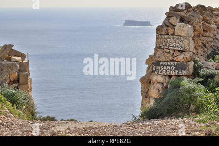 Entrée privée avec salle et pas d'entrée (Eingang Verboten) le lettrage sur les falaises de Dingli avec l'île maltaise de Filfla en arrière-plan. Malte, l'Europe. Banque D'Images