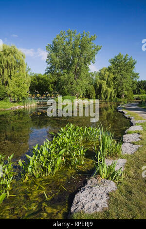 Étang avec passerelle et un belvédère au printemps, Centre de la Nature, Saint-Vincent-de-Paul, Laval, Québec, Canada. Banque D'Images