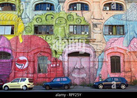 ROME - Un squated ancienne caserne militaire à Ostiense est couvert avec de gigantesques visages exotiques par l'artiste italien BLU. Banque D'Images