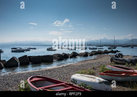 Les bateaux sur la plage de Milazzo, près de Messine, Italie. Certains blocs de béton agissent comme une réparation à partir de vagues Banque D'Images