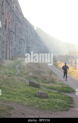 ROME - Jogger près d'un aqueduc dans le brouillard matinal du Parco degli Acquedotti. Banque D'Images