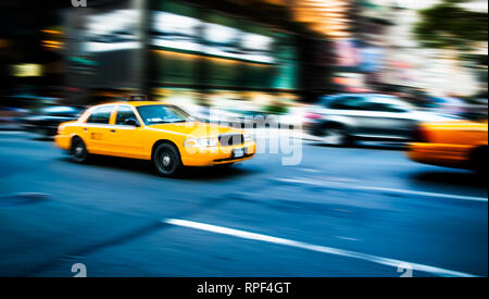 NEW YORK, USA - JUL 16,2010 : yellow cab traditionnel taxi de New York City en mouvement rapide avec le flou du panoramique, dans les rues animées de Manhattan, Banque D'Images