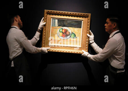 Londres, Royaume-Uni. 21 Février, 2019. Christie's employés posent avec des œuvres de Paul Cézanne "Nature morte de peches et poires' (Still Life avec des pêches et poires) Maison de vente aux enchères chez Christie's à Londres, le jeudi 21 février, 2019. La pièce va être vendu aux enchères au cours de Christie's vente du soir le mercredi. Il est estimé pour atteindre un chiffre d'affaires de jusqu'à £20millions de dollars. Photographie : Crédit : Luke MacGregor/Alamy Live News Banque D'Images