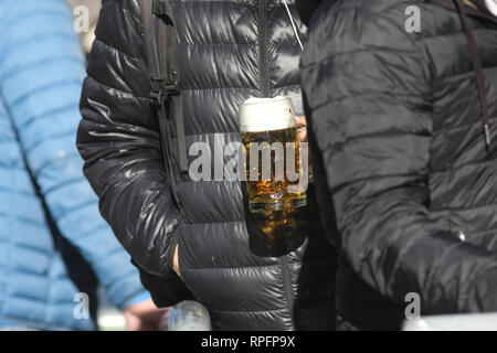 Les gens faisant la queue pour obtenir de la bière allemande fraîche sur le début du printemps. Sun est le repérage de lieux et rend le brillant liquide. Banque D'Images