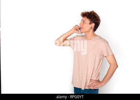 Boucles d'adolescent avec studio isolated on white permanent répondant à l'appel de téléphone professionnels side view Banque D'Images