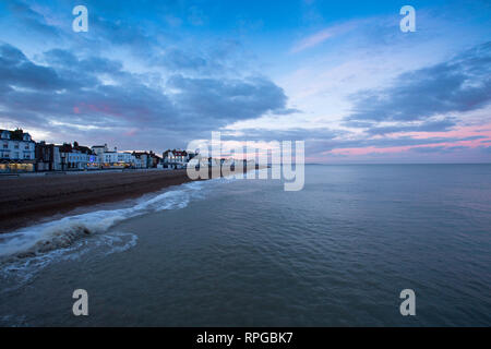 Les nuages roses pendant le coucher du soleil prises à partir de la jetée de Deal au cours de février avec les édifices le long de la Beach Street, Deal, Kent, UK. Banque D'Images