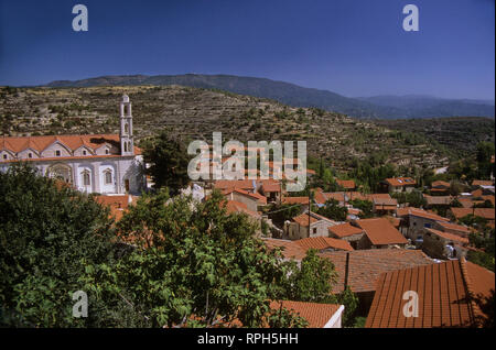 Vue sur l'église et toits rouges avec des contreforts des montagnes au loin : village de Lofou, Limassol, Chypre District Banque D'Images