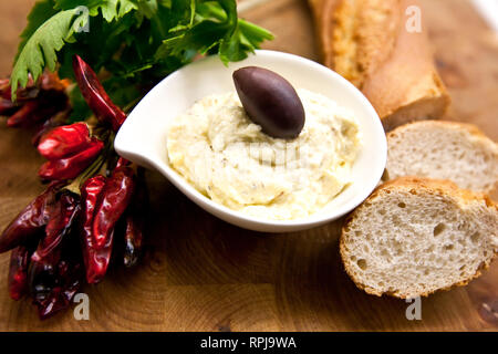 Dans Tirokafteri traditionnelle assiette blanche décorée avec du chili, le pain blanc et le persil. Banque D'Images