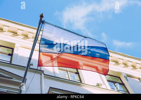 Riga, Lettonie. Drapeau russe près de l'immeuble. Journée ensoleillée et froide. Photo de voyage urbain 2019. 21 février. Banque D'Images