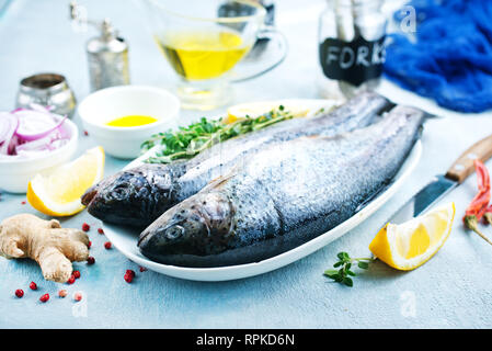 Le poisson cru à bord et sur une table Banque D'Images