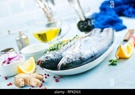 Le poisson cru à bord et sur une table Banque D'Images