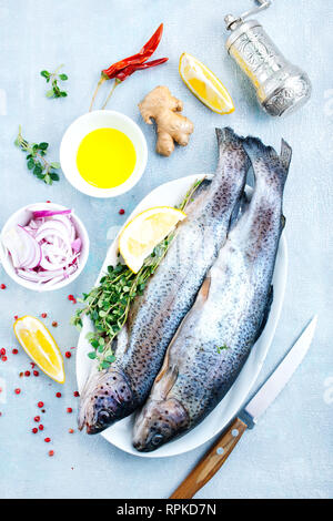 Le poisson cru à bord et sur une table Banque D'Images