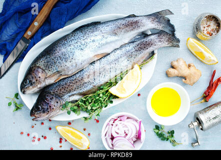 Le poisson cru à bord et sur une table Banque D'Images