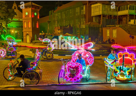 Les trishaws colorés, une forme de location-powered, pousse-pousse que dans la nuit de croisière autour de la ville de Malacca Ville Banque D'Images