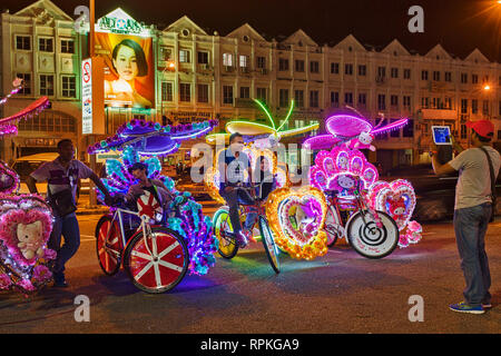 Les trishaws colorés, une forme de location-powered, pousse-pousse que dans la nuit de croisière autour de la ville de Malacca Ville Banque D'Images