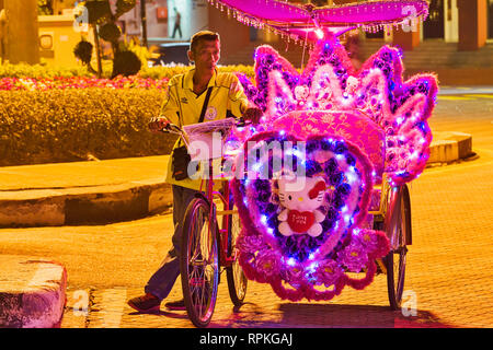 Les trishaws colorés, une forme de location-powered, pousse-pousse que dans la nuit de croisière autour de la ville de Malacca Ville Banque D'Images