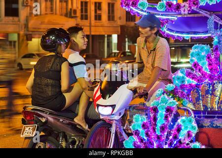 Les trishaws colorés, une forme de location-powered, pousse-pousse que dans la nuit de croisière autour de la ville de Malacca Ville Banque D'Images