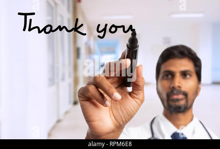 Médecin ou infirmier indien écrit merci avec marqueur noir sur l'écran de verre invisible que montrer gratitude concept Banque D'Images