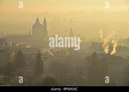 Matin d'hiver dans le quartier de Mala Strana - partie historique de Prague. Église Saint Nicolas. Le lever du soleil. Le brouillard. Vue depuis le monastère de Strahov. Banque D'Images