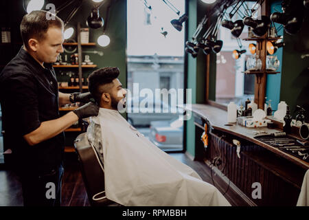 Heureux guy se coupe par coiffure dans un salon de coiffure Banque D'Images
