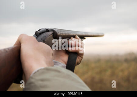 Hunter avec de vieux fusil de chasse en attente de prier dans les bois Banque D'Images