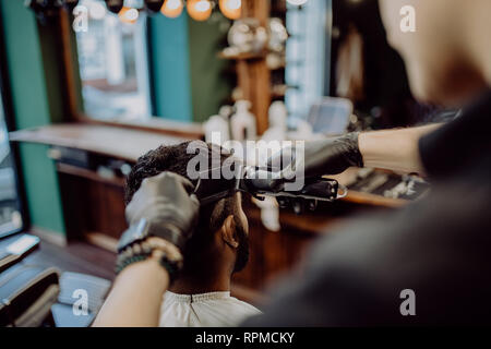 Portrait of handsome man with beard dans ce type. Coiffure travailler avec un rasoir électrique faire en coupe coiffure Banque D'Images