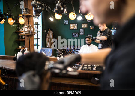 Portrait of handsome man with beard dans ce type. Coiffure travailler avec un rasoir électrique faire en coupe coiffure Banque D'Images