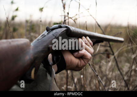 Hunter avec de vieux fusil de chasse en attente de prier dans les bois Banque D'Images