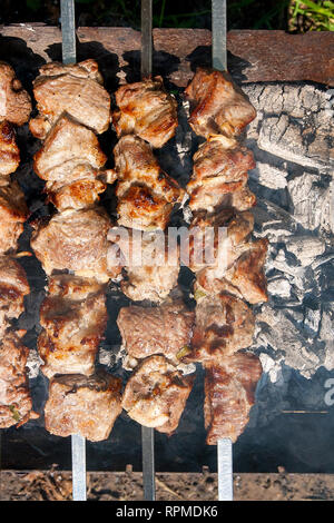 Kebab grillés cuisson sur metal brochette. Faites des brochettes de cubes de viande sur les brochettes au cours de cuisson sur le mangal sur charbon de bois à l'extérieur. Sur le grill Banque D'Images
