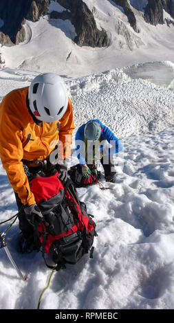 Les alpinistes prennent une pause en haut d'un glacier des Alpes françaises sur le chemin de la barre des Écrins mountain peak Banque D'Images