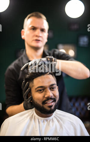 Les barbiers part propagation de la poudre de talc sur les clients professionnels avec cou blaireau en salon de coiffure pour hommes soin de beauté.concept.jeune homme noir ge Banque D'Images