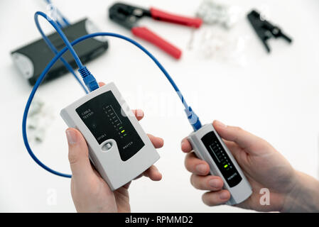 L'homme à l'aide d'un câble qualifiés tests de performances. Mesurer une Teechnician câbles connectés Banque D'Images