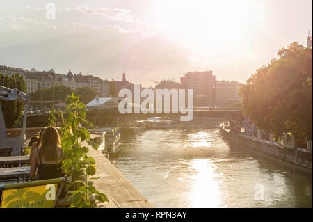 Les filles discutent dans un des cafés le long du Danube au coucher du soleil, Vienne, Autriche Banque D'Images