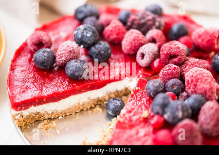 Tarte aux fruits Gâteau végétalien premières avec des biscuits, des noix de cajou de fromage à la crème, les framboises et les bleuets jelly topping, gâteau vegan frais et sain avec des baies Banque D'Images