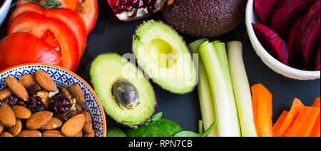 La sélection d'aliments sains Vue supérieure avec les avocats, les légumes crus, les épinards feuilles vertes, herbes et ingrédients, mélange de noix, de l'alimentation, de la nourriture végétalienne saine Banque D'Images