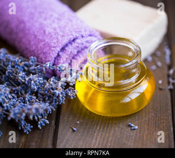 Lavender spa oil setting, spa and massage oil still life, lavender towel, flowers , natural soap and lavender oil on wooden background, wooden spa set Banque D'Images